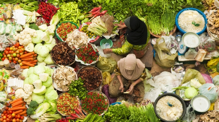 Dos vendedoras rodeadas de vegetales