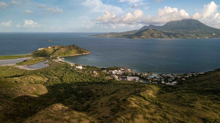 A coastal landscape with hills and a bay.