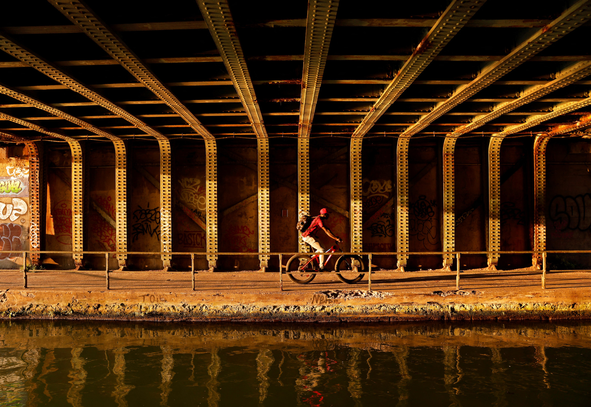A person is cycling alongside a river