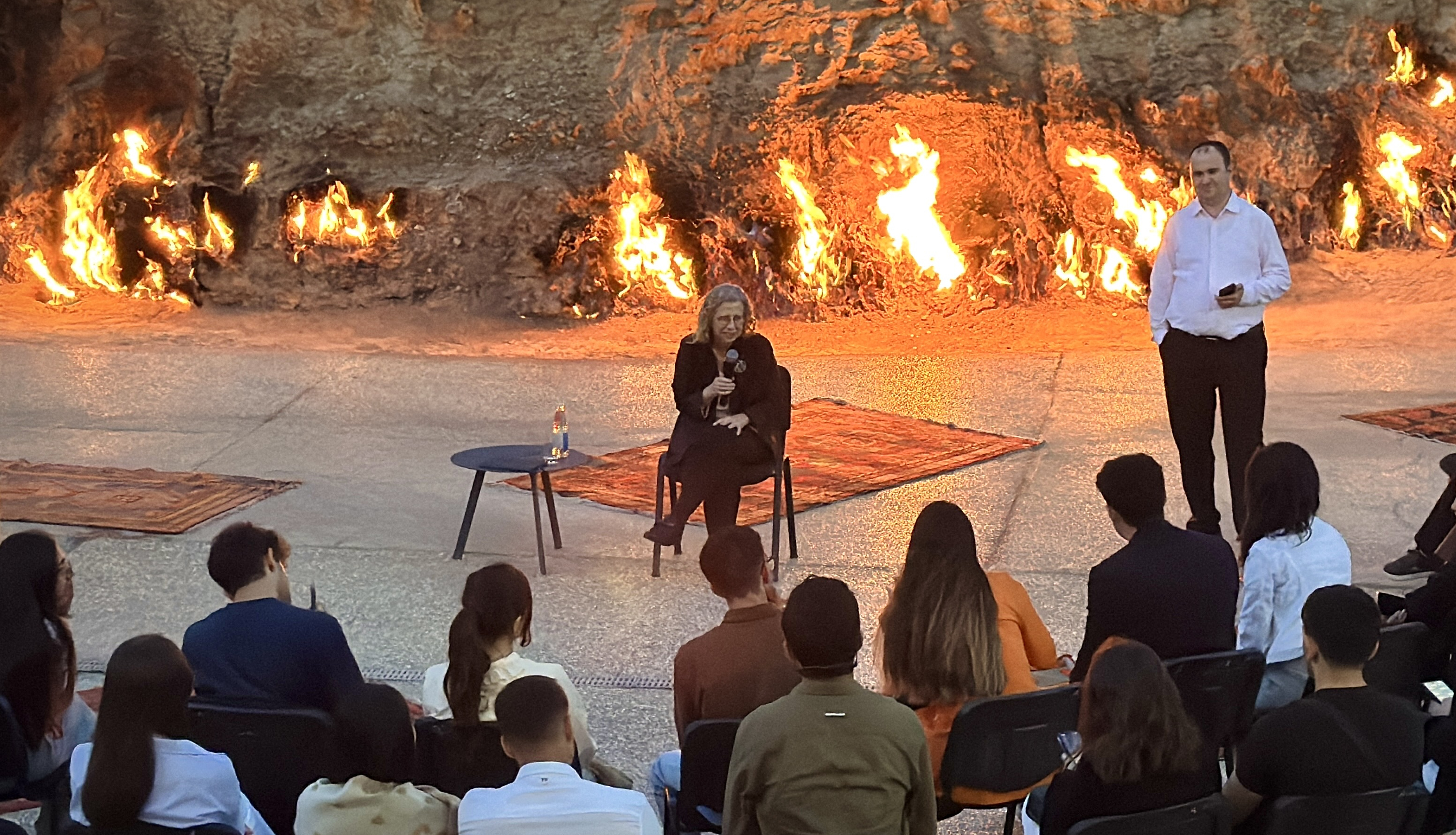 A person talking in front of flames